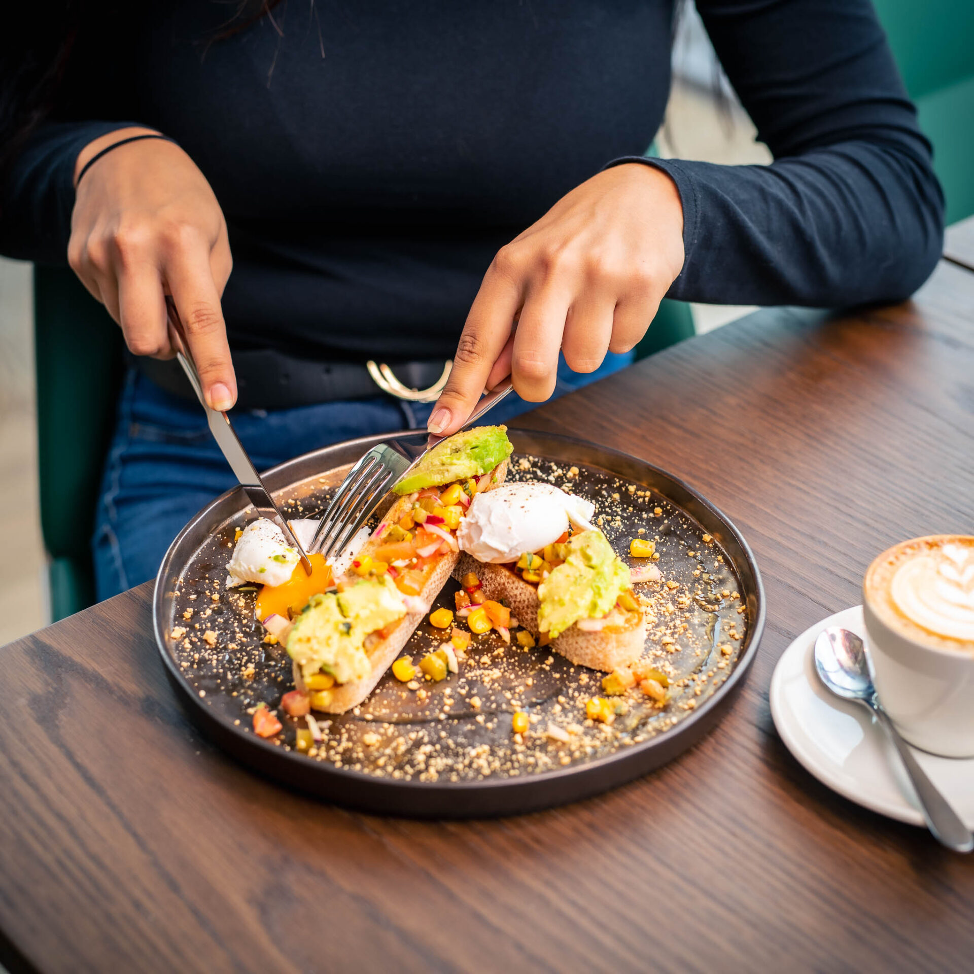 Woman cutting avocado and Egg Toast with Salsa